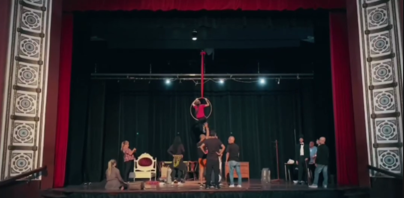 Imagen de fondo de actores en el ensayo general de cancion de navidad